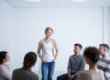 woman standing and talking during group therapy and learning about rehab insurance coverage